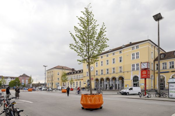 Fotografie: Blick auf den Bahnhofsvorplatz mit mobilem Grün