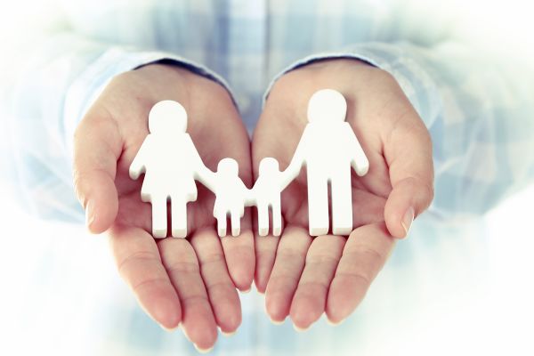 Symbolbild - Familie aus Papier in zwei Händen