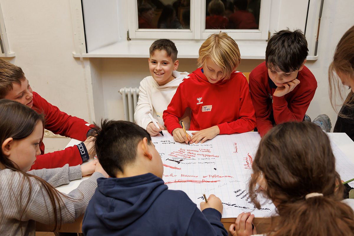 Fotografie - Kinder schreiben Ideen auf Plakat