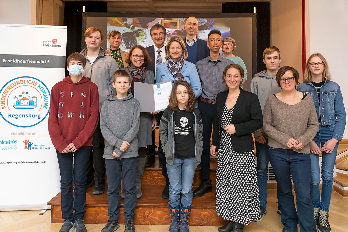 Fotografie - Gruppenbild mit Oberbürgermeisterin Maltz-Schwarzfischer, Bürgermeisterin Dr. Astrid Freudenstein und weiteren Beteiligten an der Jubiläumsfeier zur Siegelentfristung des Programms Kinderfreundliche Kommunen