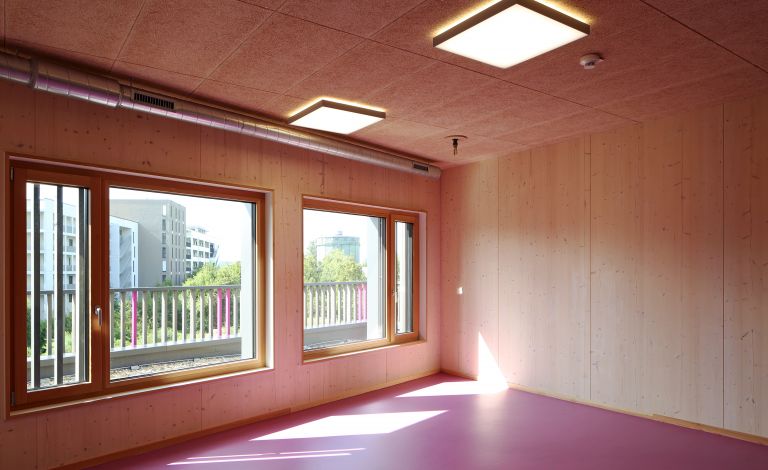 Ein Raum mit Holzwänden und drei Fenstern.