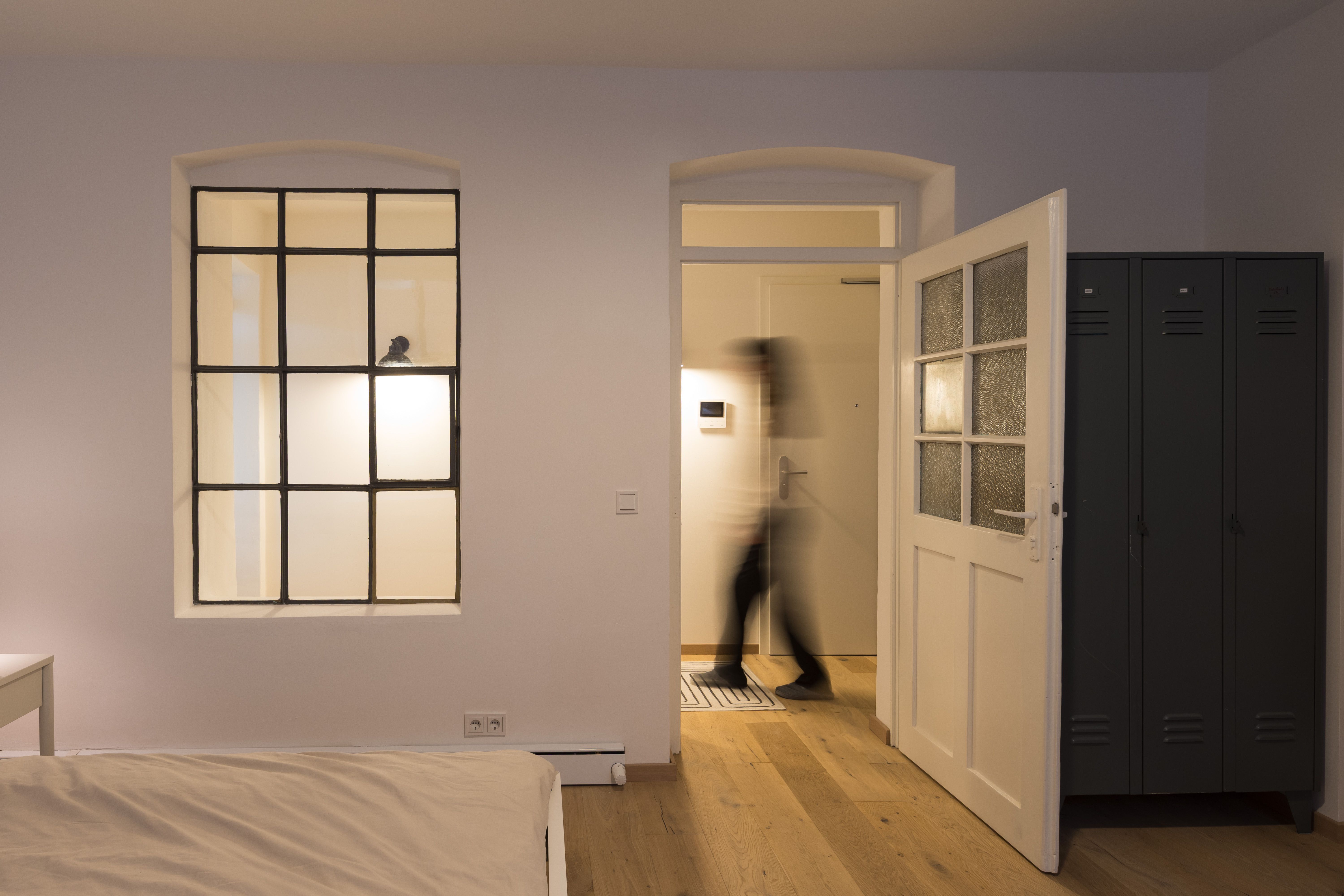 Fotografie - Atelierwohnung 1 - Die Aufnahme zeigt eine verschwomene weibliche Silhouette, die im Gang läuft.