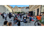 Erwachsene und Kinder schauen auf dem Kassiansplatz dem Figurentheater der compania cirkater zu.