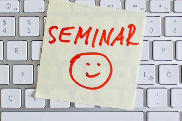 Fotografie - Klebezettel mit Text "Seminar" auf einer Tastatur