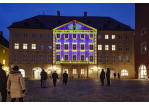 Foto des Monats - Dezember 2020 - Bunt beleuchtetes Gebäude mit Menschen davor
