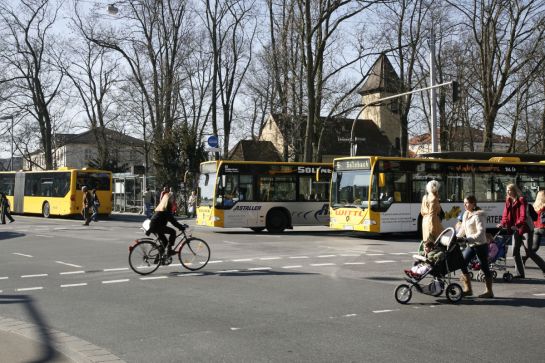 Fussgänger, Radfahrer und Busse am Busbahnhof