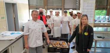 Bäcker und Bäckerinnen überreichen Gebäck an eine Vertreterin der "Tafel"