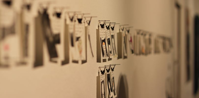 Fotografie, Kunstwerke im Postkartenformat hängen an einer Schnur