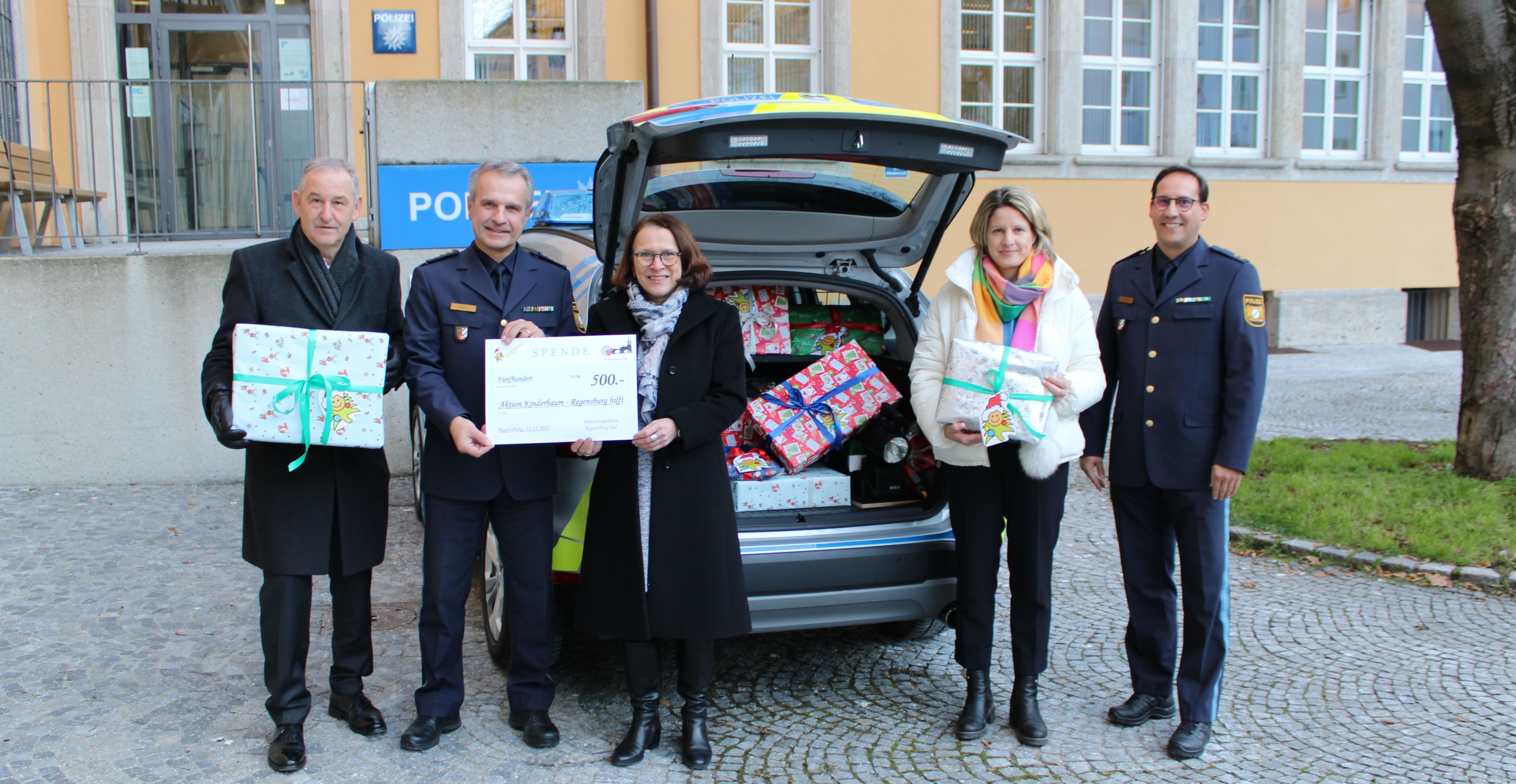 Fotografie-Mitarbeitende der Polizeiinspektion Süd übergeben an die Oberbürgermeisterin Gertrud Maltz-Schwarzfischer, an die Bürgermeisterin Dr. Astrid Freudenstein und an den Bürgermeister Ludwig Artinger einen Spendenscheck über 500 € und zahlreiche Geschenke.