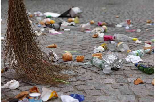 Fotografie - auf dem Bild sieht man liegen gelassene bzw. weggeworfene Essensreste, Flaschen, Verpackungsmaterial und anderen Müll