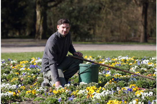 Fotografie: Matthias Peter kniet in einem Blumenbeet