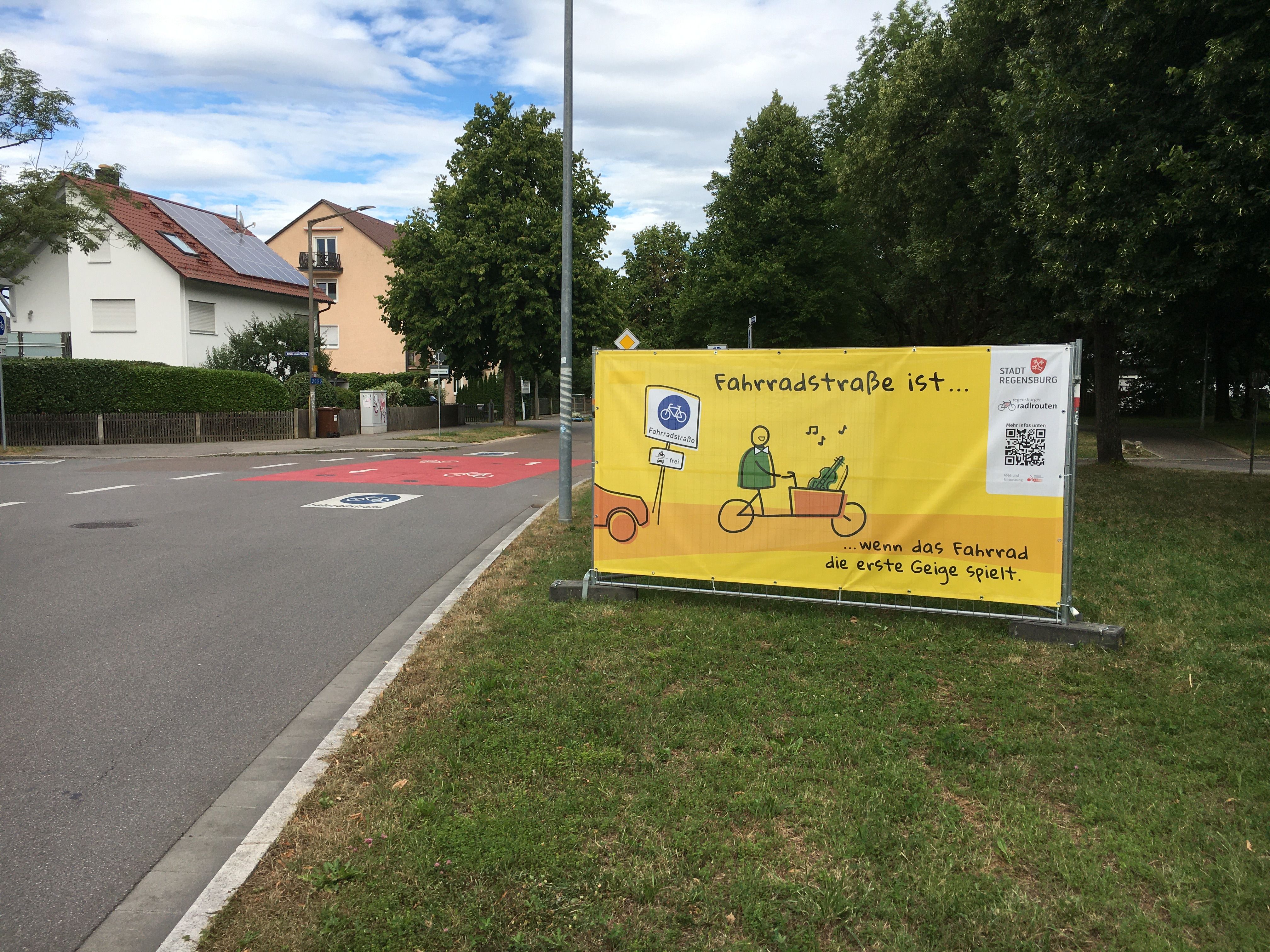 Fotografie eines gelben Banners mit dem Spruch "Fahrradstraße ist... wenn das Fahrrad die erste Geige spielt."