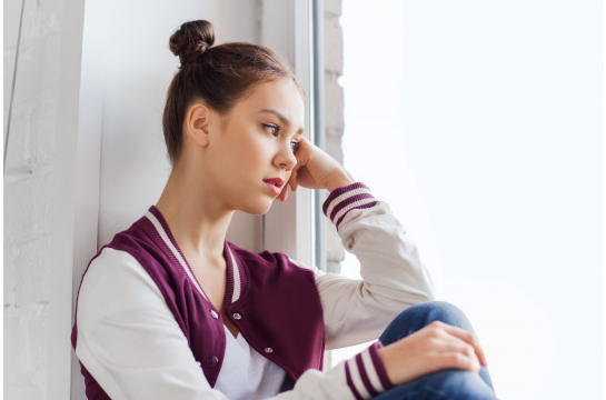 Fotografie: Jugendliche sitzt am Fenster