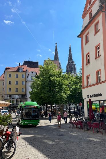 Fotografie - Fußgänger flanieren am Kohlenmarkt, während ein Elektrobus vorbeifährt