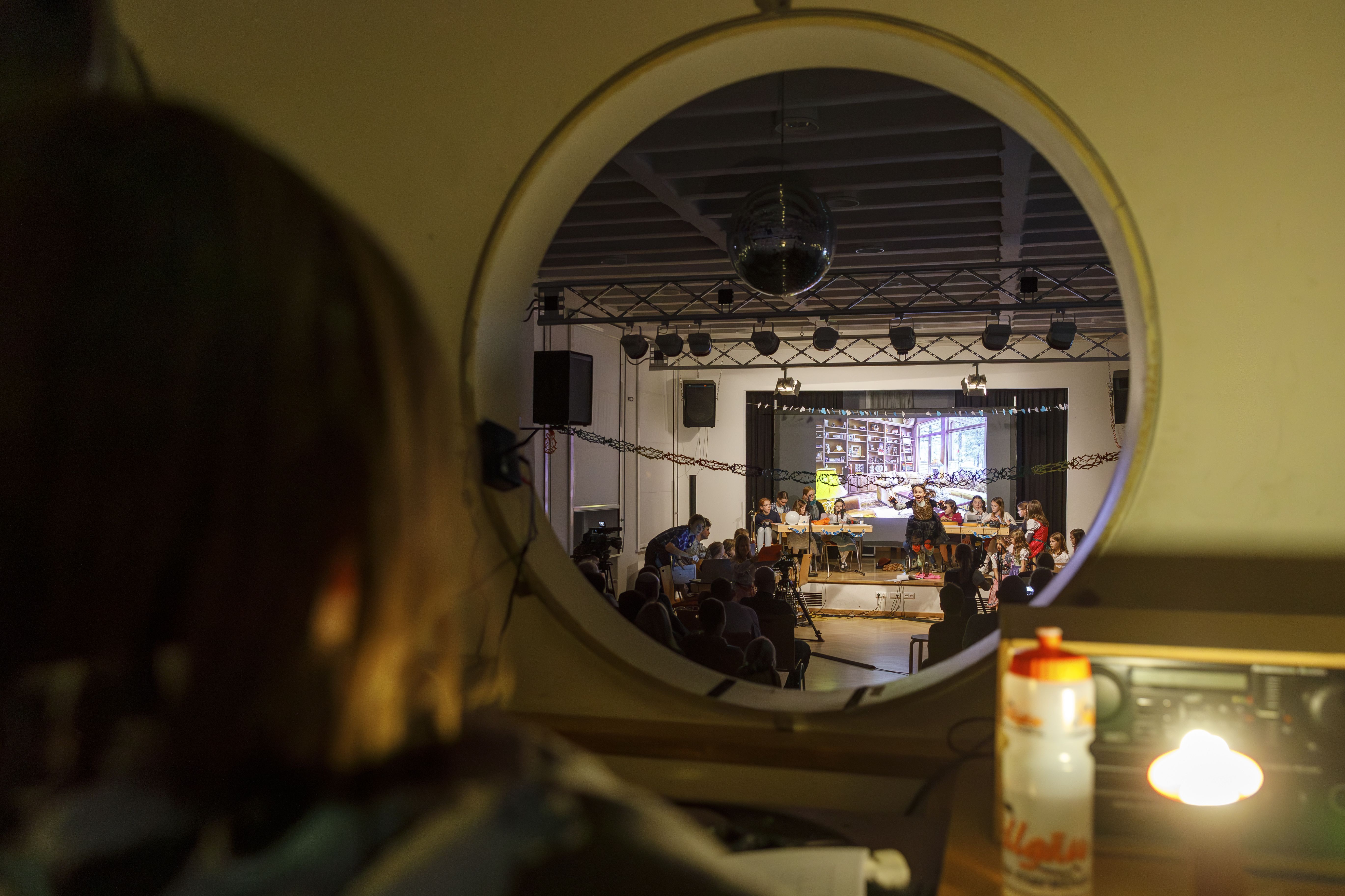 Rundes Fenster in einen Saal mit Bühne