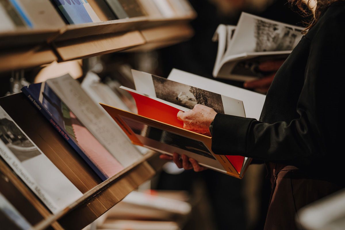 Fotografie – Person mit offenem Buch in der Hand