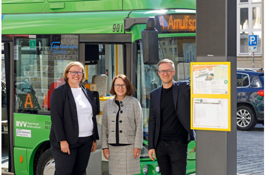 Fotografie: Sandra Schönherr, Betriebsleiterin der das Stadtwerk Regensburg.Mobilität GmbH, Oberbürgermeisterin Gertrud Maltz-Schwarzfischer und Fabian Effhauser, zuständiger Projektleiter beim Amt für Wirtschaft und Wissenschaft, an der neuen Bushaltestellen-Stele am Domplatz