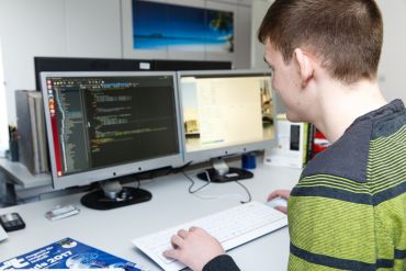 Fotografie - Nachwuchskraft arbeitend vor einem PC