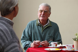 Themenbild Senioren - Hilfe im Alter - Fotografie - zwei Senioren sitzen an einem Tisch im Gespräch