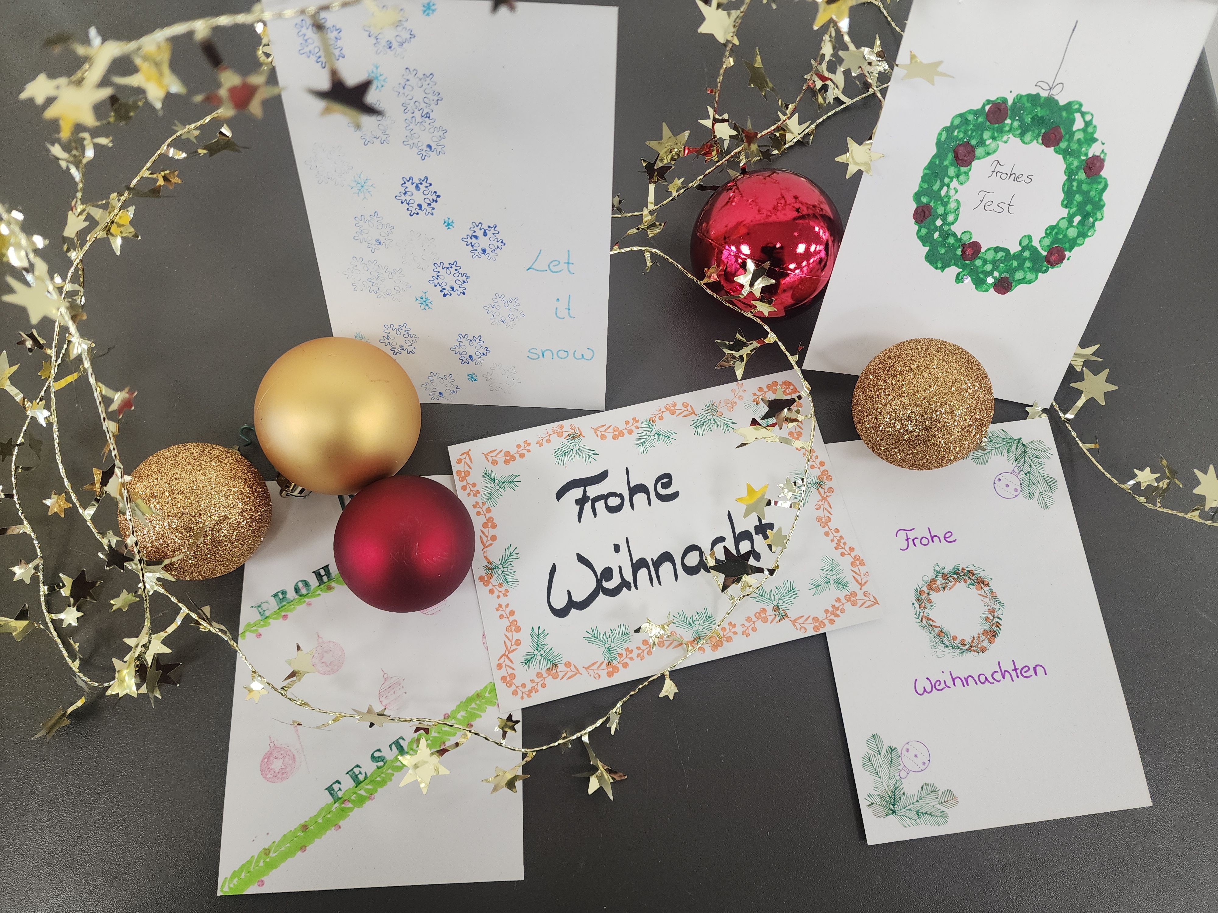 Weihnachtskarten auf dem Tisch mit Aufschrift "Frohe Weihnachten" und Weihnachtsdekoration