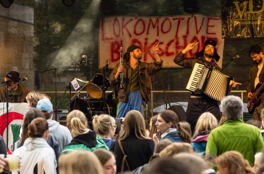 Themenbild Veranstaltungen - Fotografie - vier Musiker auf der Bühne mit Publikum im Vordergrund