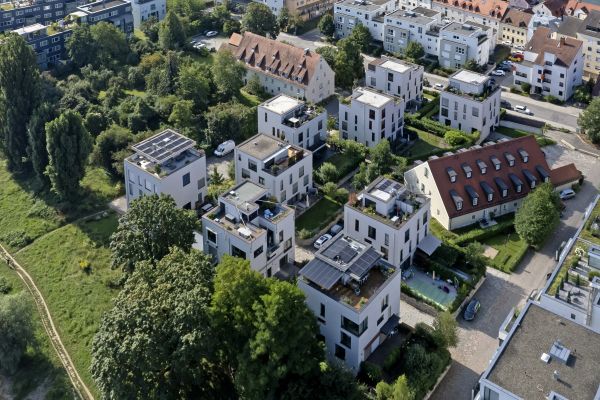 Luftaufnahme mit Blick auf Hausdächer, Straßen, Bäume und Autos