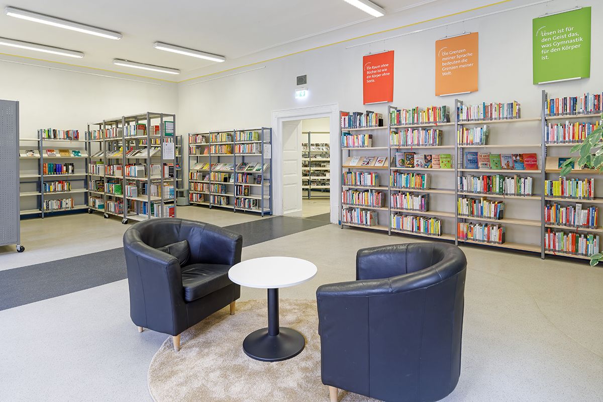 Zwei Sessel zwischen Bücherregalen