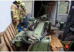 Zwei Feuerwehrmänner begutachten die umgestürzte Maschine