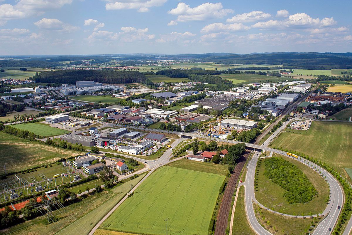 Fotografie - Luftbildaufnahme vom Gewerbegebiet Haslbach aus südlicher Richtung, links im Bild Gebäude von Haslbacher Unternehmen, rechts ist die Pilsen Allee zu sehen