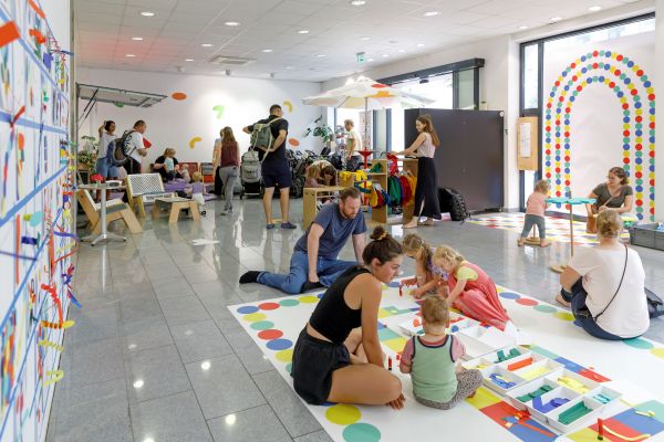 Fotografie: Familien mit Kindern spielen im M26 auf dem Boden