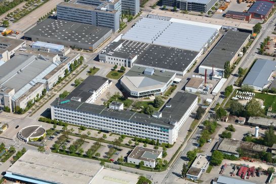 Unternehmen - Luftbildaufnahme des Standortes in der Siemensstraße mit Blick auf Parkhaus, Kindertagesstätte und Casino