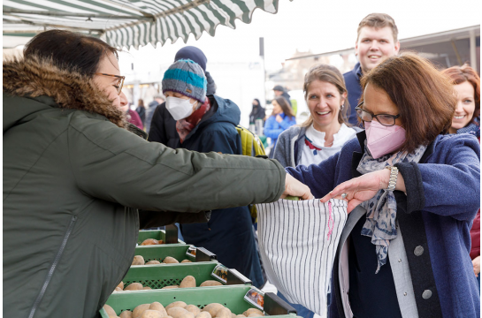 Zwei personen an einem Marktstand.