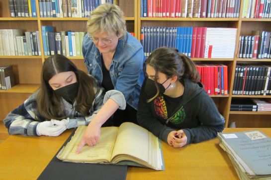 Fotografie: Martina Köglmeier mit zwei Schülerinnen bei der Quellenarbeit im Archiv