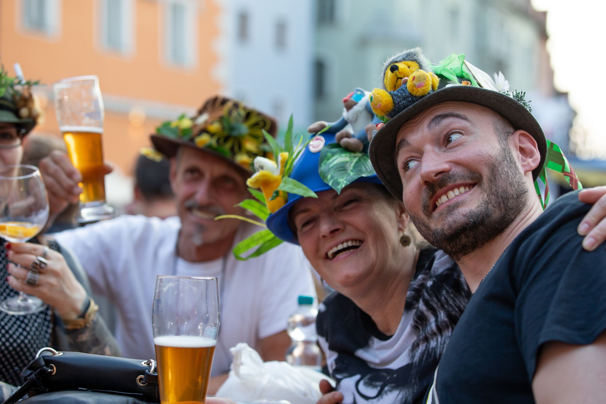 Fotografie: Lachende Menschen mit bunt dekorierten Hüten