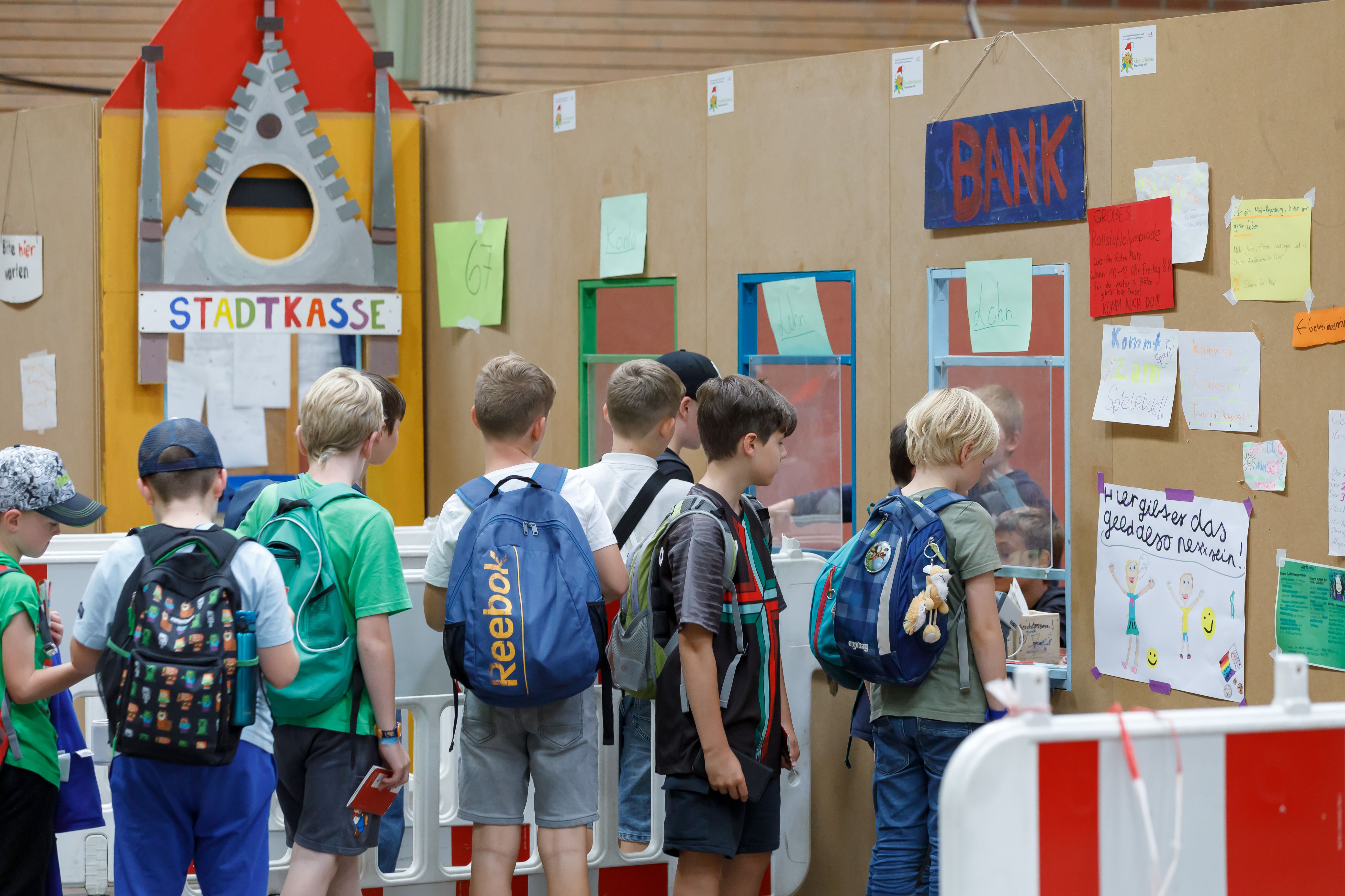 Fotografie: Kinder stehen in einer Schlange vor der Mini-Regensburg-Bank