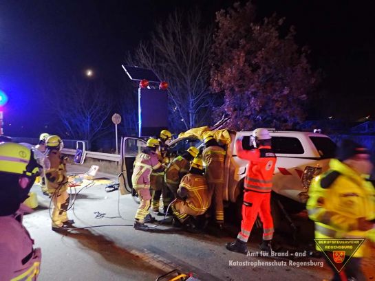 Fotografie: Einsatzkräfte von Feuerwehr und Rettungsdienst bei der Rettung einer Person aus einem verunfallten PKW.